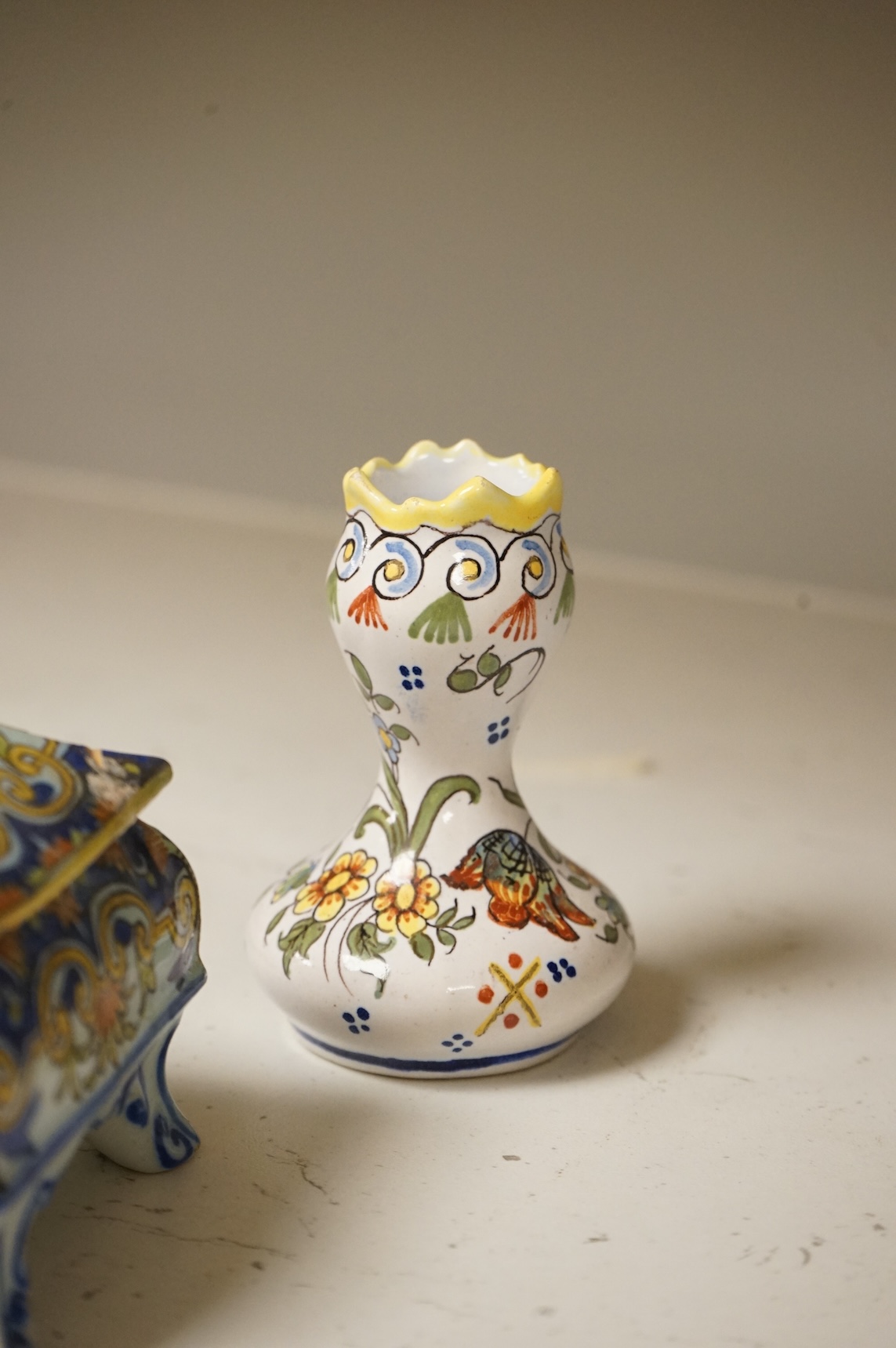A group of French faience pottery to include spill vases, an ink well and dishes, largest 21cm high